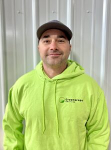 Smiling employee wearing a Greenscape hoodie